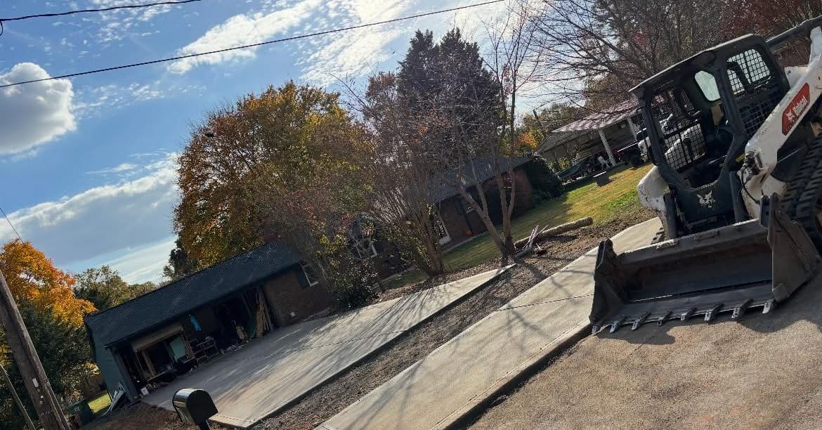 Concrete driveway replacement with bobcat prepping subgrade, Charlotte NC
